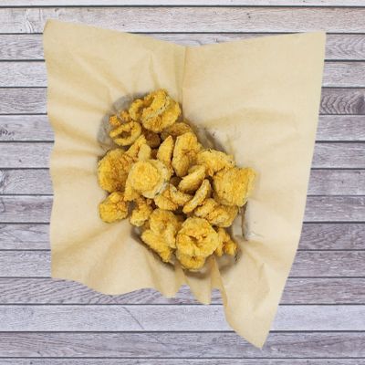 Basket of fried Pickles on brown paper.