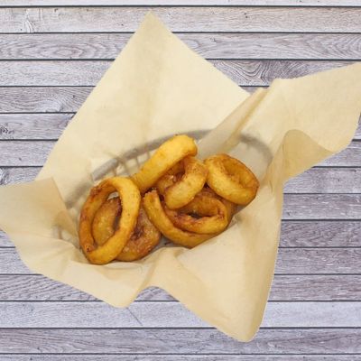 Golden crispy onion rings in a basket.