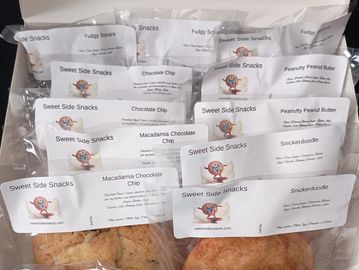 Assorted packaged baked goods labeled Sweet Side Snacks with flavors like Snickerdoodle and Macadamia Chocolate Chip.