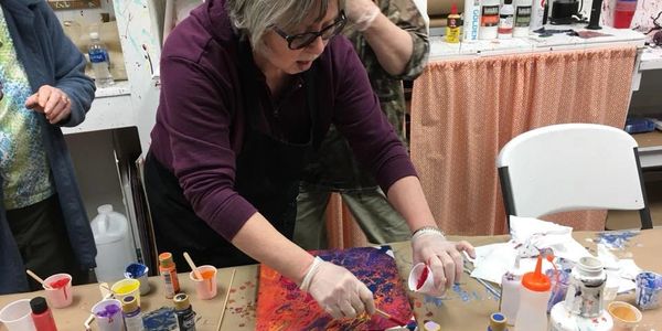 artist pouring paint