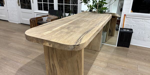 A solid wooden table with a natural finish in a modern room setting.
