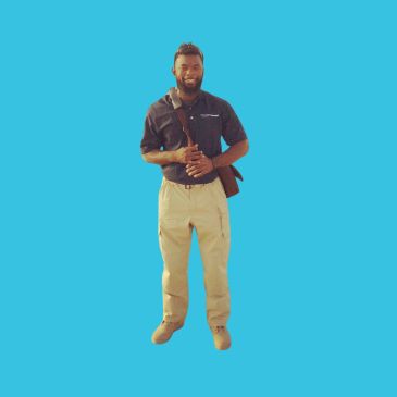 Man standing with a bag on shoulder against blue background.