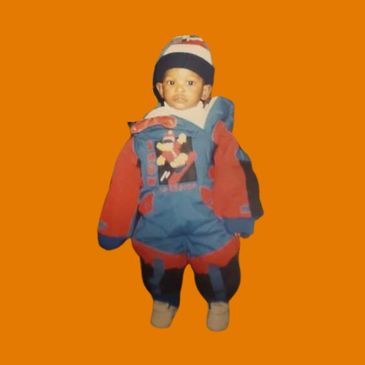 Child wearing colorful winter outfit and hat.