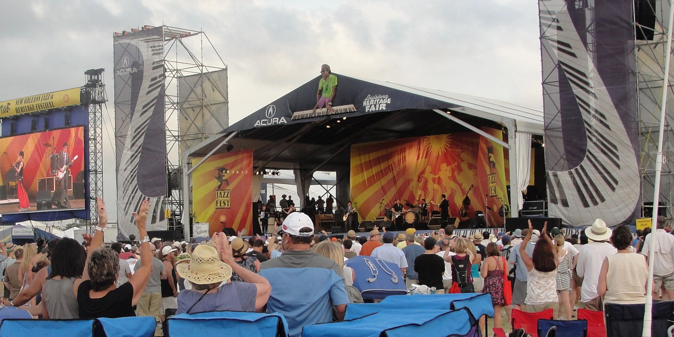 Crowd enjoying live music at New Orleans Jazz &amp; Heritage Festival stage.