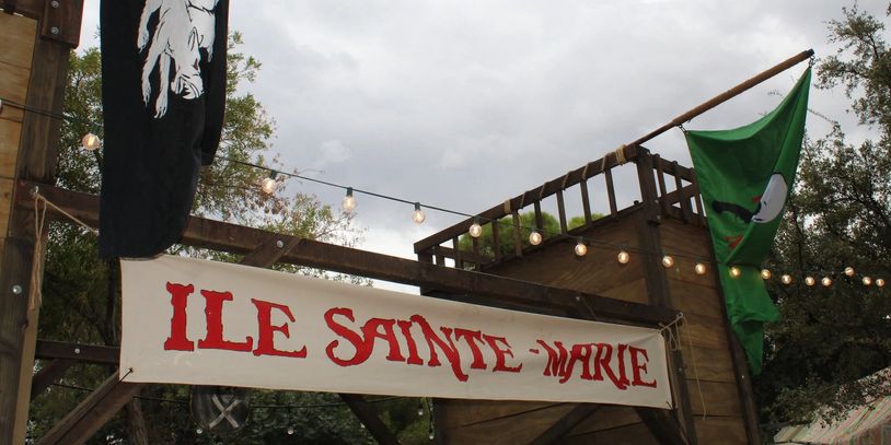 A sign reads Ile Sainte-Marie with flags and string lights.