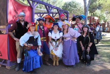 Group in colorful pirate costumes at a fair.