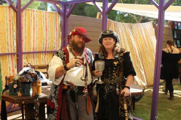 Two people dressed in pirate costumes at an outdoor event.