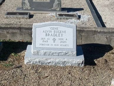 A gray granite slant headstone in a cemetery. 