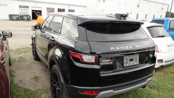 Black Range Rover Evoque parked outdoors near other vehicles.
