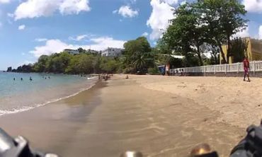 Sunny beach with clear skies and calm waves.