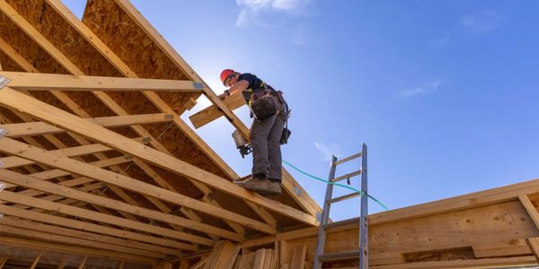 Roofer installing shingles on a house