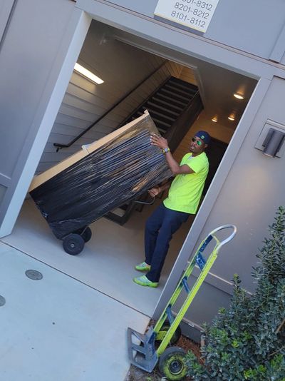Grab And Go Movers moving a fully shrink-wrapped item at Chastain Hill Apartments in Douglasville.