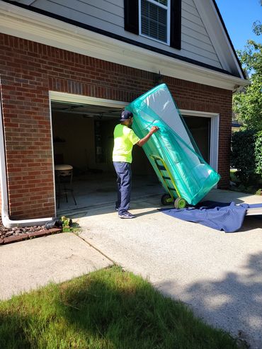 Mover from Grab And Go Movers in Atlanta, GA loading sofa onto moving truck in Mableton, GA. 