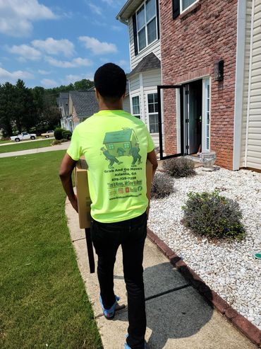 15 year old in Atlanta Ga carrying a chair and boxes into new home.