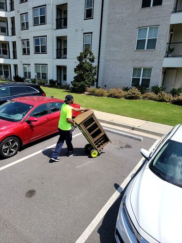 Mover unloading a cabinet at Series At Riverview Landing in Mableton, GA.