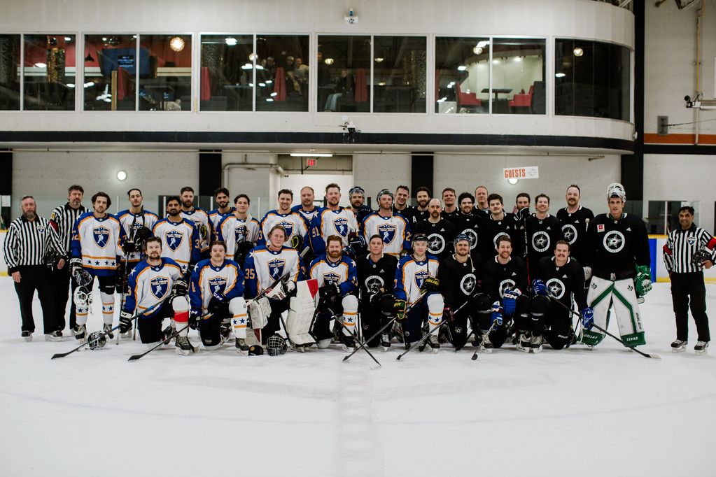 Two hockey teams posing together on the ice rink.