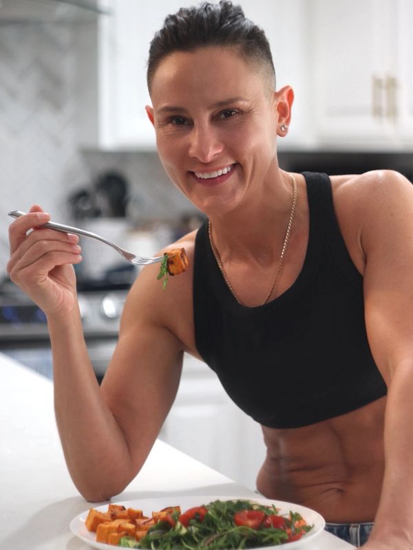 A fit person enjoying a healthy meal in a bright kitchen.