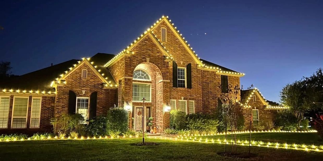 House decorated with warm white string lights at night.