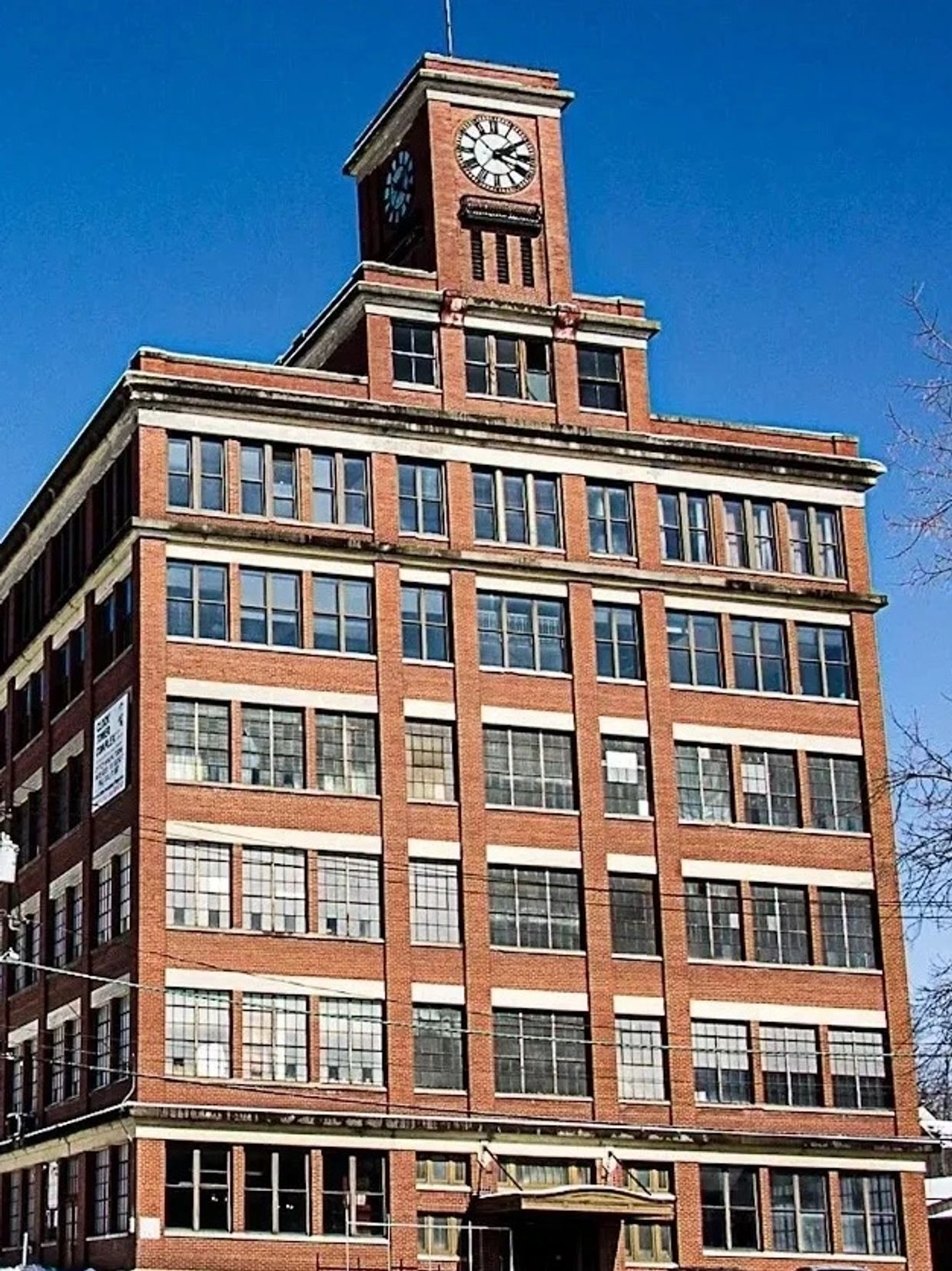 Historic brick building with a prominent clock tower under a clear blue sky.
