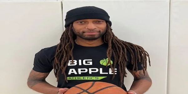 Man with dreadlocks holding a basketball.