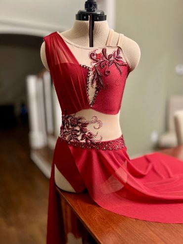 Red embellished dance or performance costume on a dress form.