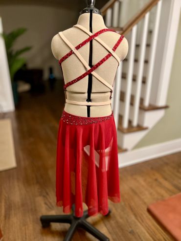 Red dance dress with sparkling straps on a mannequin.