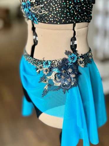 Elegant dance costume with blue and black floral details.