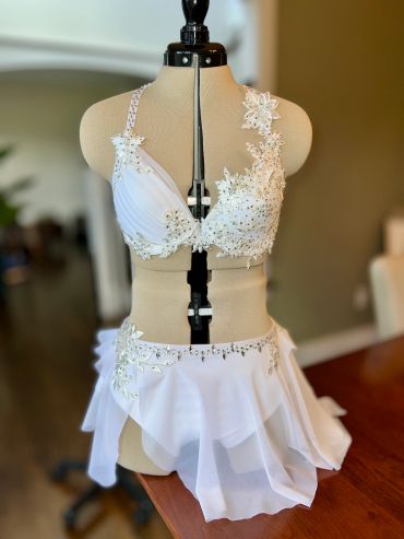 White embellished dance costume on dress form.