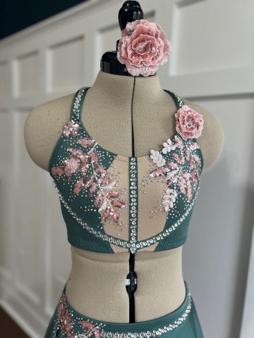Green and pink embellished dance costume on mannequin.