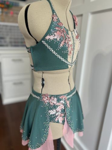 Green and pink embellished dance costume on mannequin.