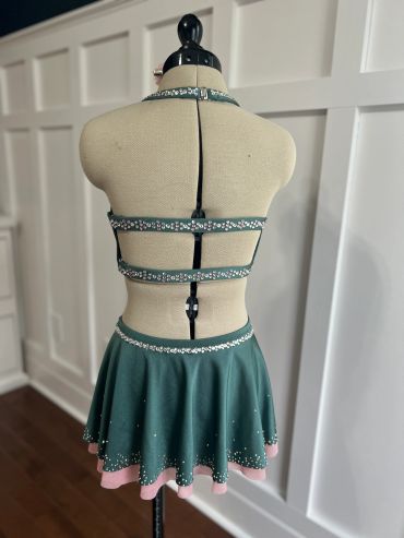 Back view of a green and pink dance costume on a mannequin.