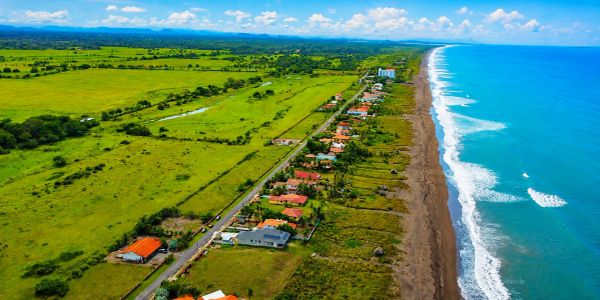 Vista aérea de una costa con casas y campos verdes.