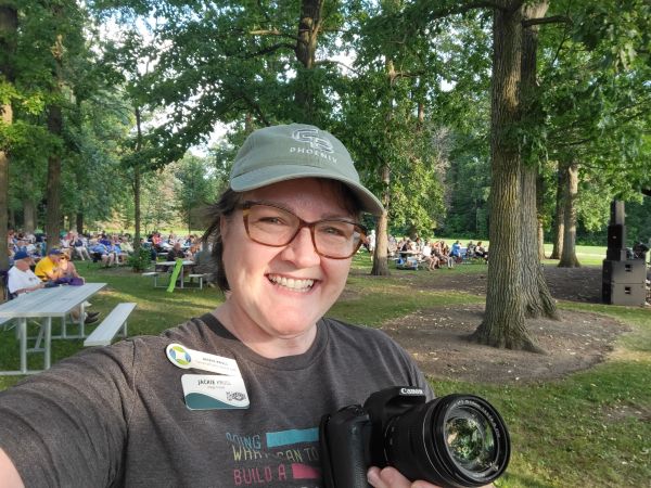 Person smiling for a selfie holding a camera