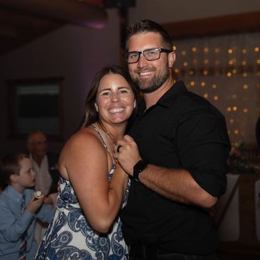 Smiling couple embraces at a festive indoor event.