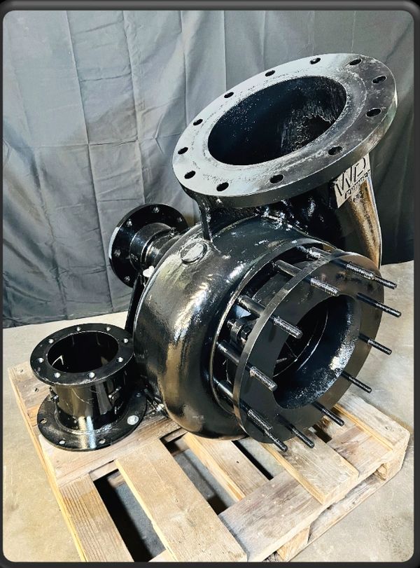 Large industrial pump casing on a wooden pallet in a workshop.