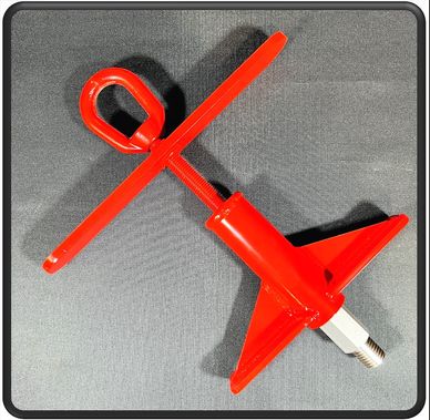 Red metal tool with a threaded end and triangular base on a gray surface.