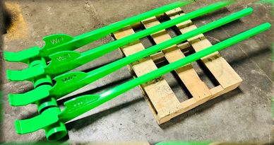 Four bright green metal tools laid on a wooden pallet on concrete floor.
