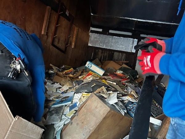 Acluttered garage, filled with packed boxes, storage bags. and other items that have taken over 