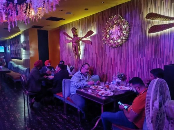 People dining in a cozy, dimly lit restaurant with purple lighting.