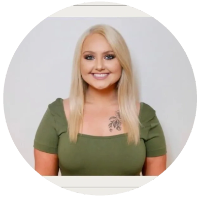 Smiling blonde woman in a green top.