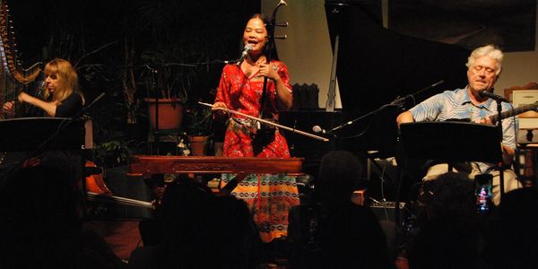 Musicians performing on stage with traditional instruments.