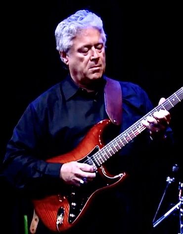 Man playing electric guitar on stage.