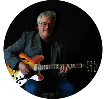 Older man playing an electric guitar.
