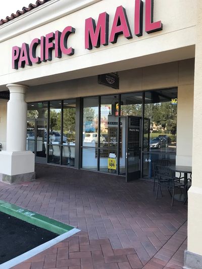 Exterior of Pacific Mail shipping and mailing store with glass doors.