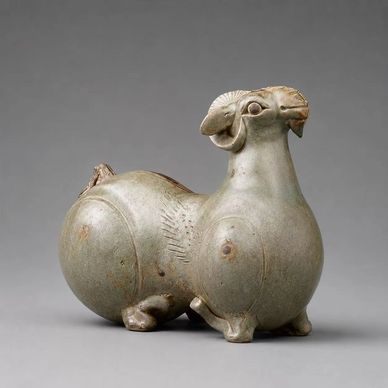 Ancient jade sculpture of a ram with detailed features.