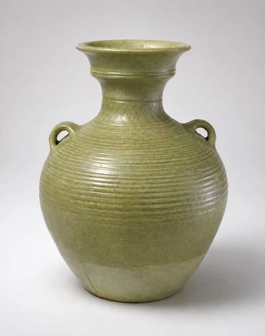 Green ceramic vase with two small loop handles and horizontal ridges.