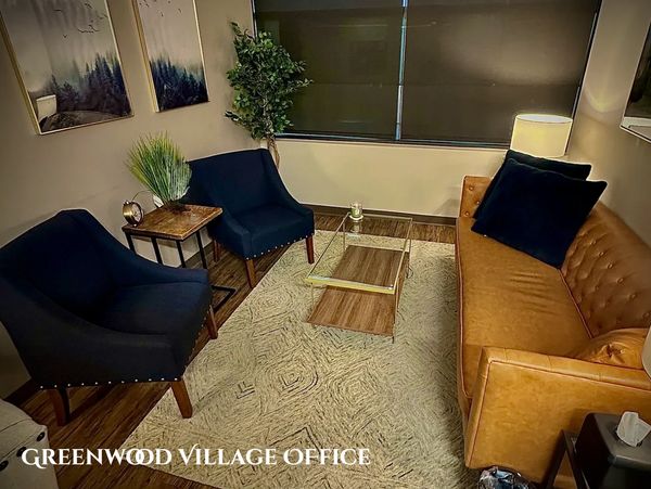 Cozy office lounge with leather sofa and blue chairs.
