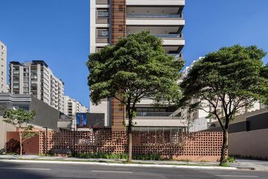 Modern residential buildings with trees along the sidewalk.