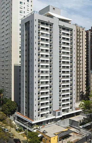 Tall residential building in an urban area with balconies and adjacent high-rises.