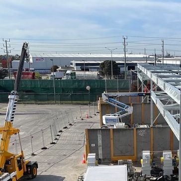 Construction site with cranes and building structures under a clear sky.
